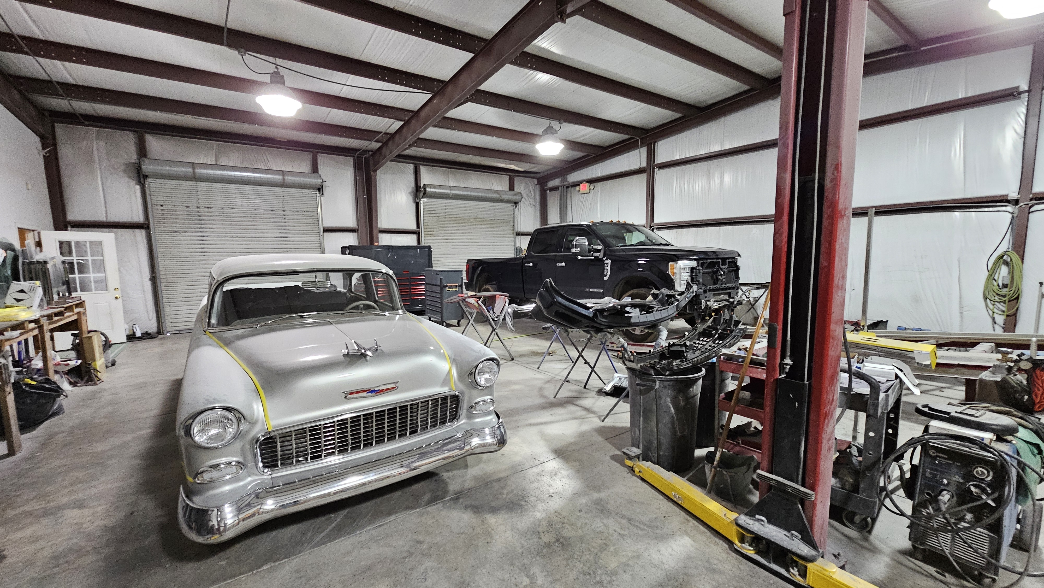 Shop floor with a 1955 Chevy and a truck in progress